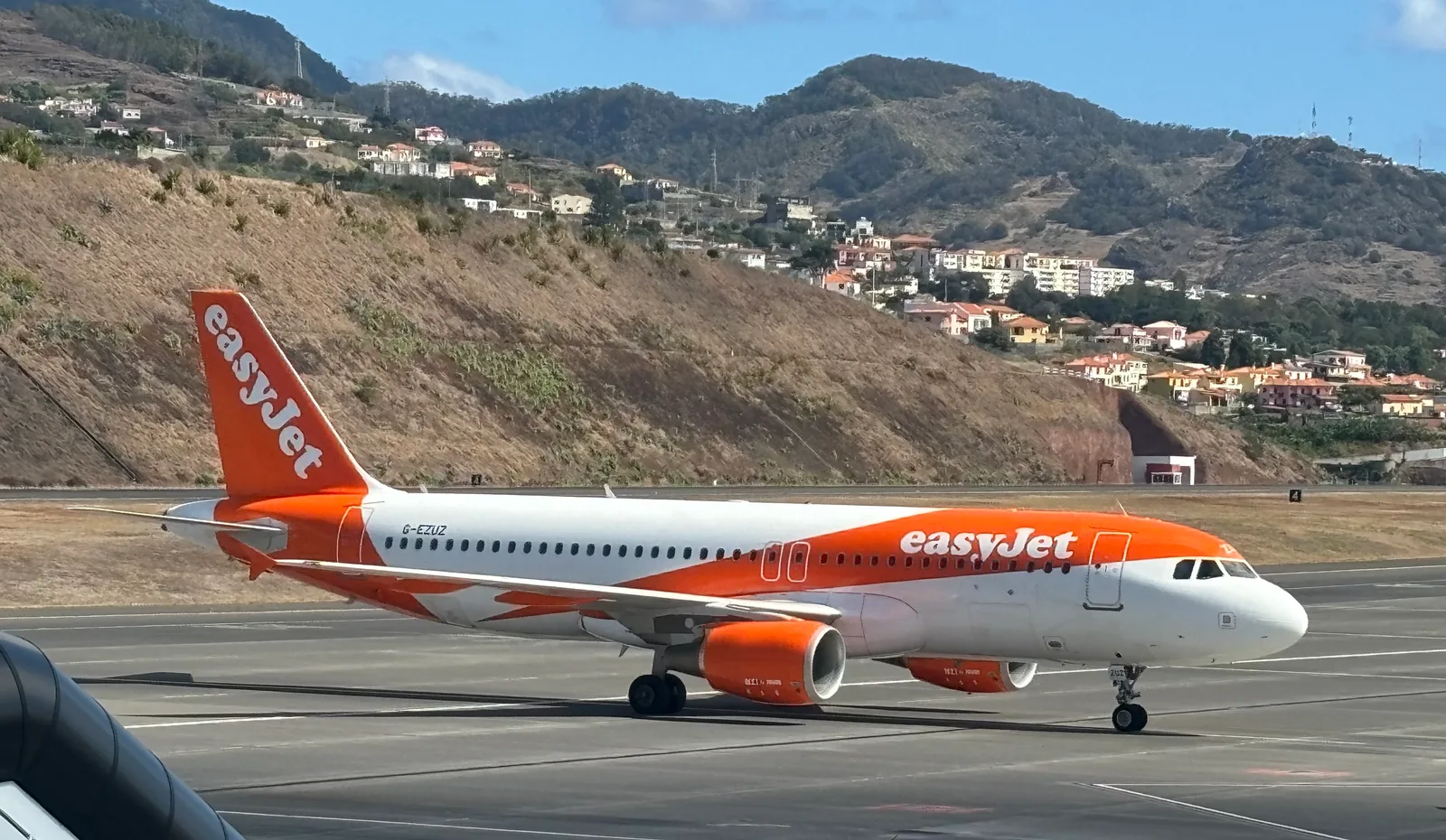 Pomarańczowo-biały Airbus A320 easyJet na lotnisku Funchal na Maderze