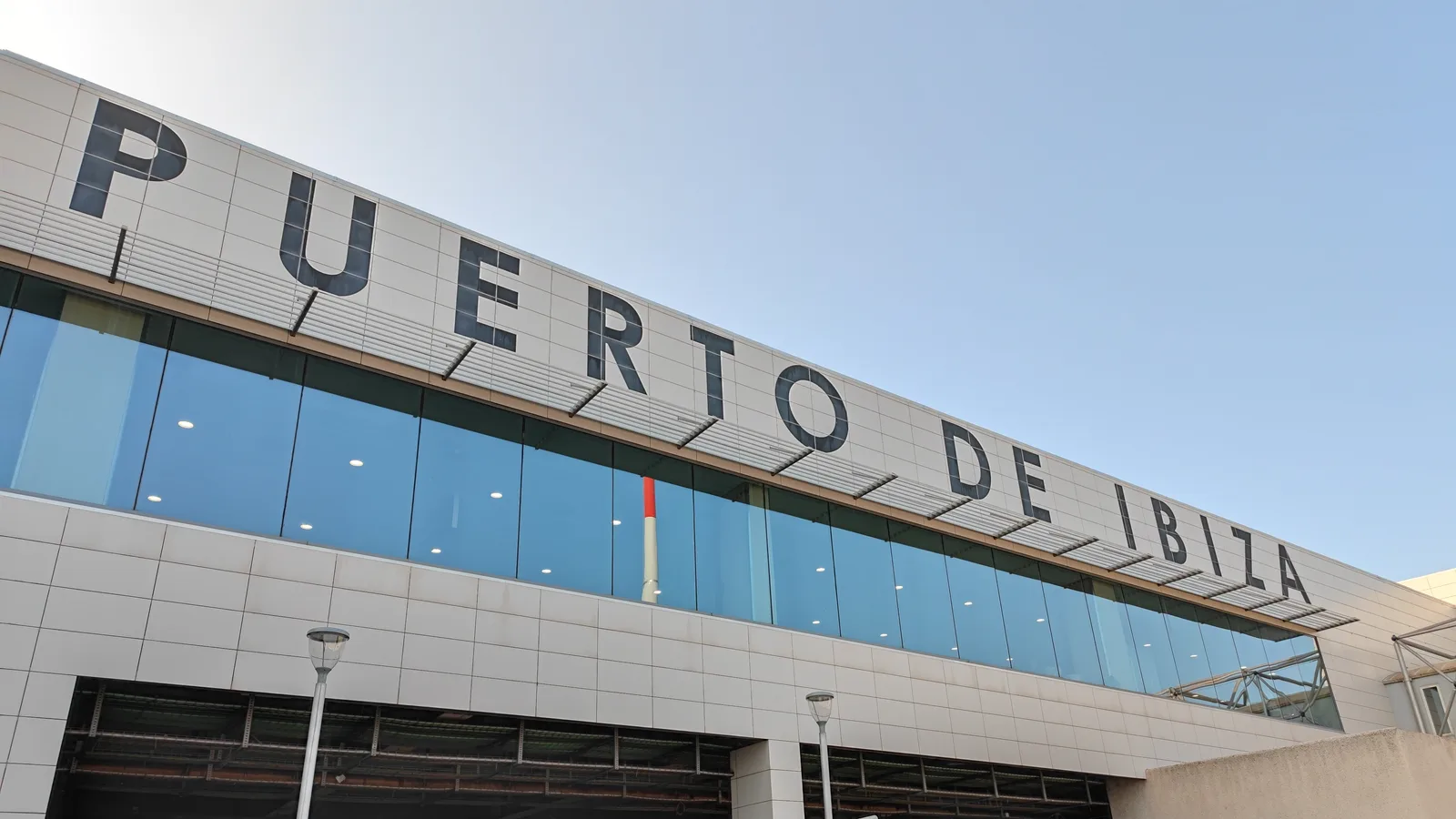 Façade du terminal de l’aéroport d’Ibiza avec de grandes lettres et des baies vitrées